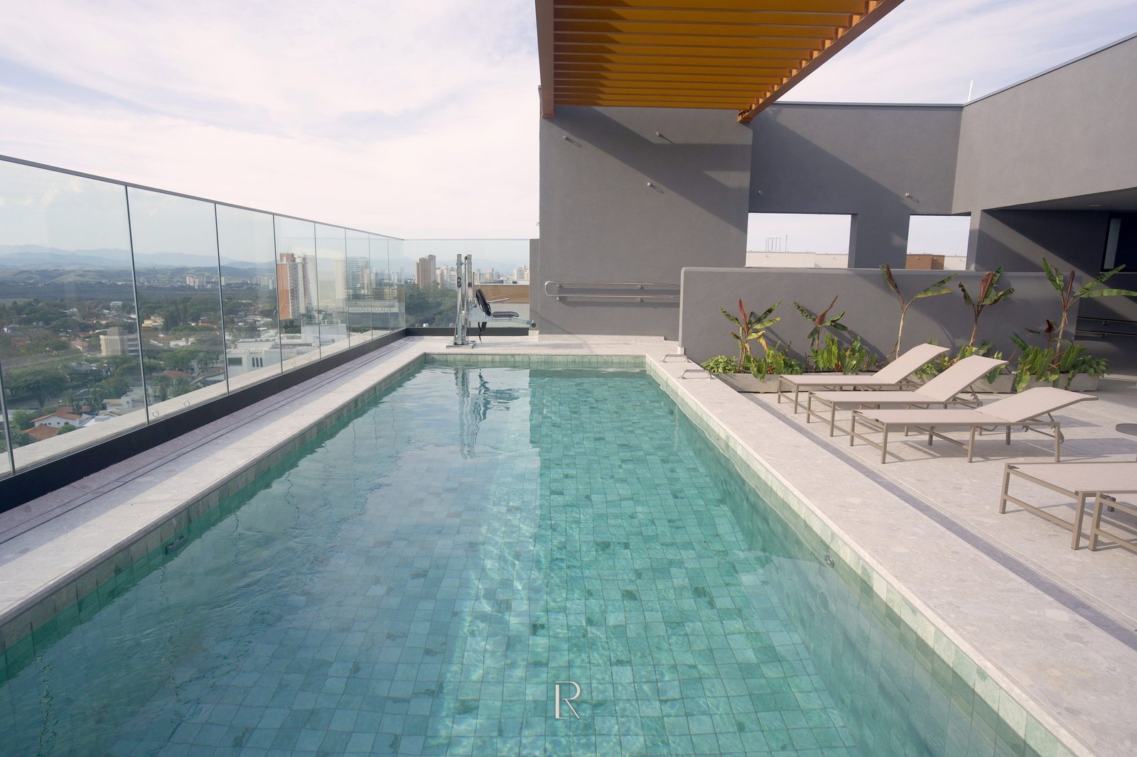 Piscina do rooftop do Matiss, com revestimento verde-água e espreguiçadeiras